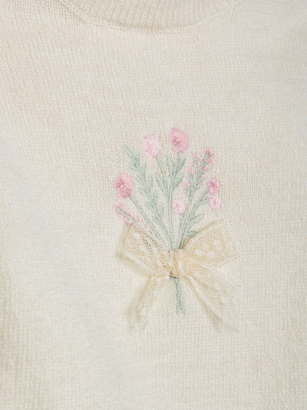 Ecru knit sweater with a design on the front