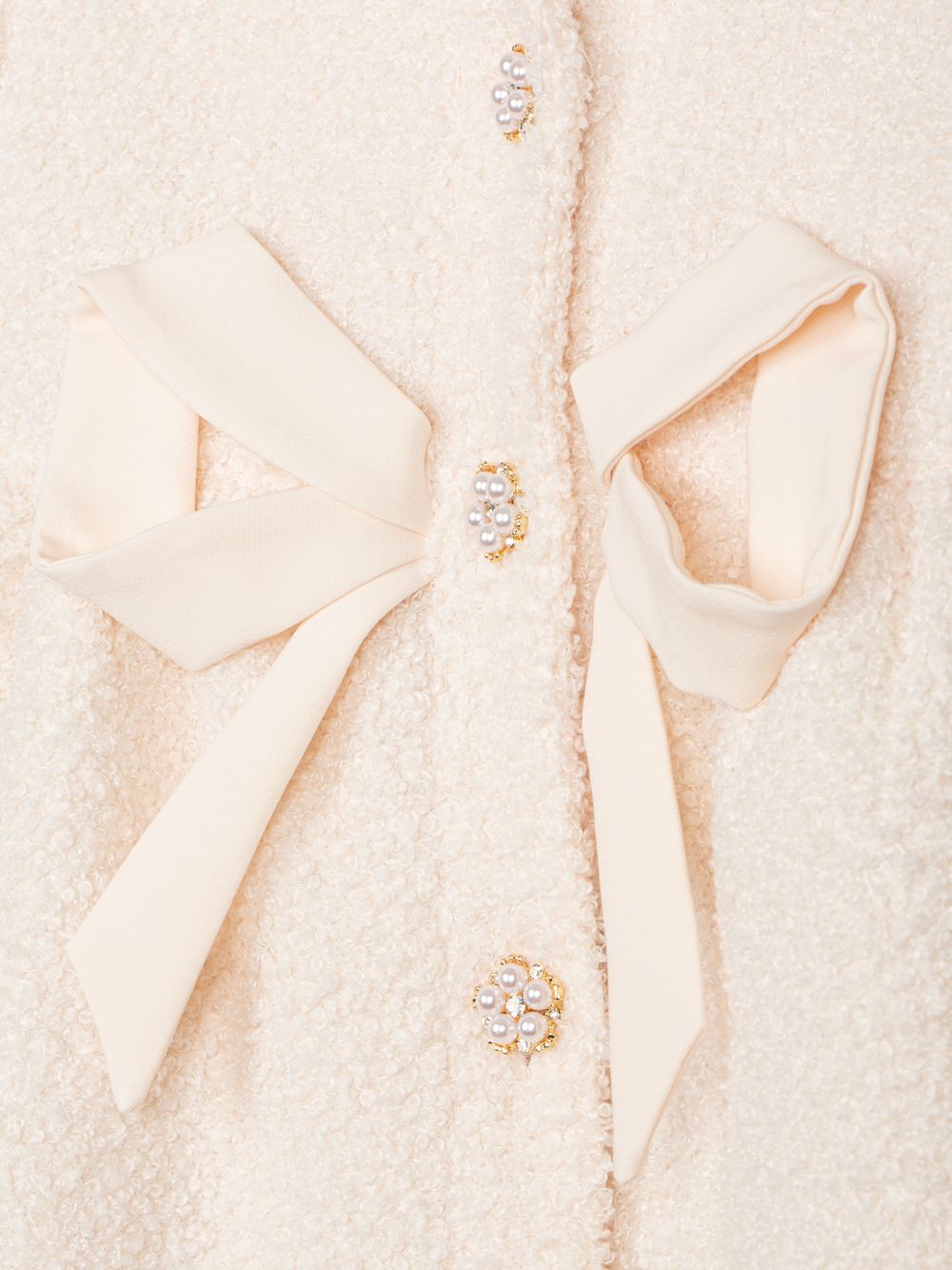 Beige bouclé coat with an elegant bow
