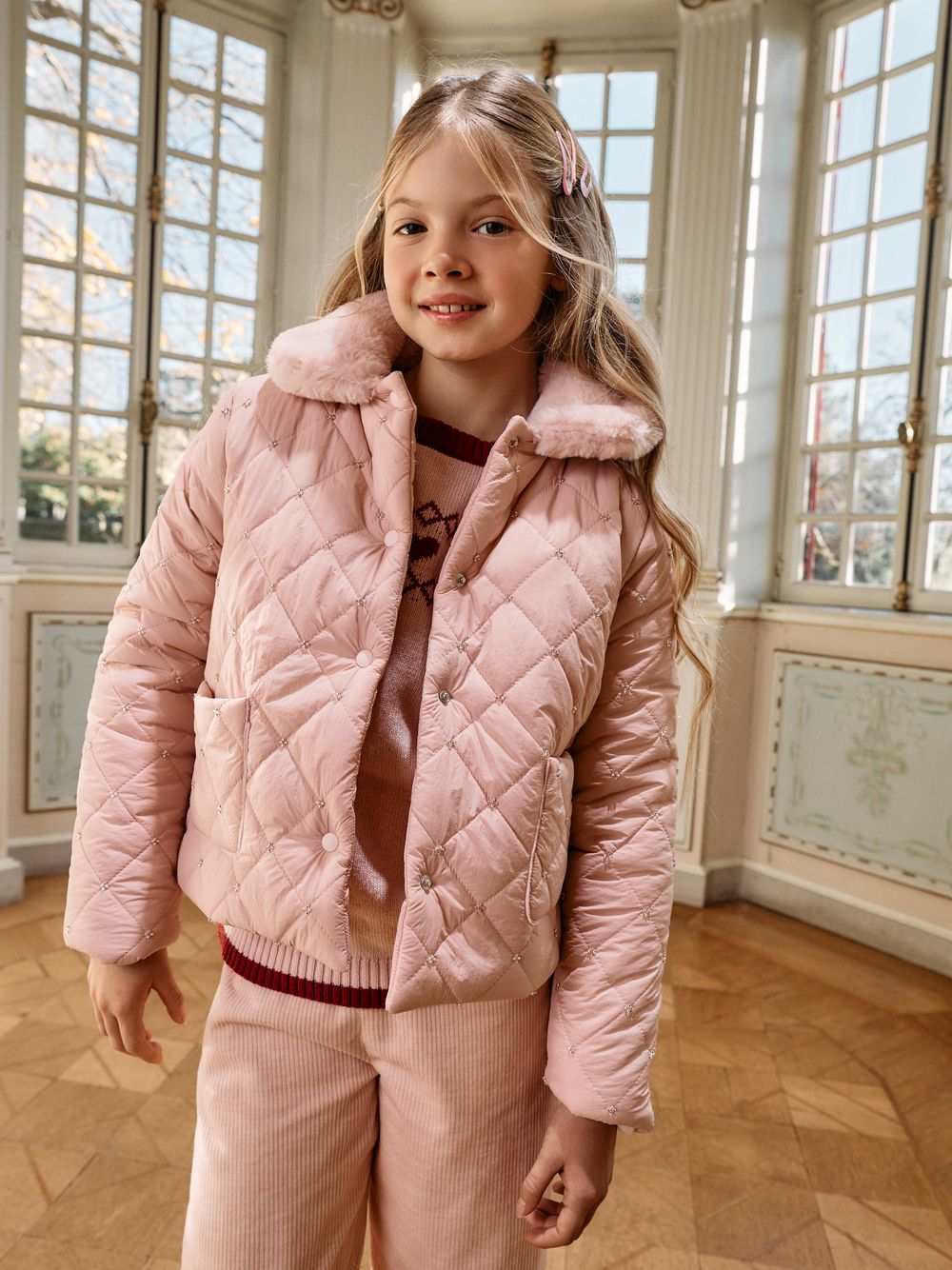 Pale pink coat with a fur collar and elegant details